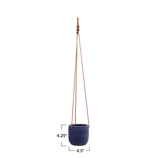 A navy blue stoneware planter with a leather rope hanger, displayed against a white background.
