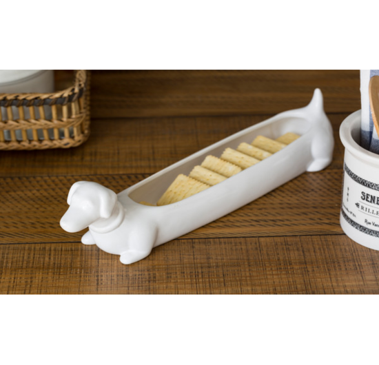 A long white ceramic dish in the shape of a dachshund.