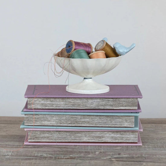 Antique white and blue scalloped metal bowl with three-dimensional birds on the rim.