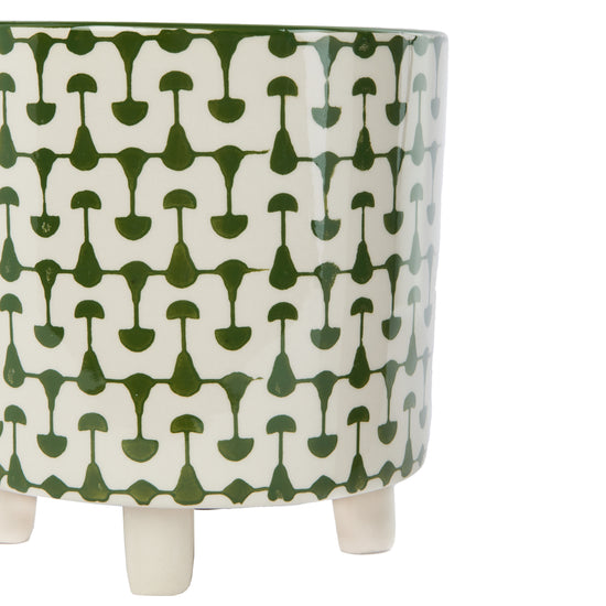 A green and white footed stoneware planter with an abstract geometric print.