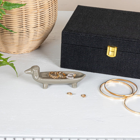 A gray ceramic dish in the shape of a dog.