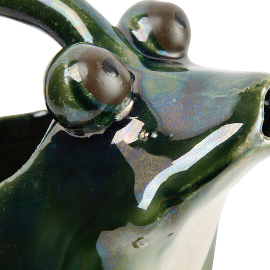A green stoneware watering pitcher designed to resemble a frog.