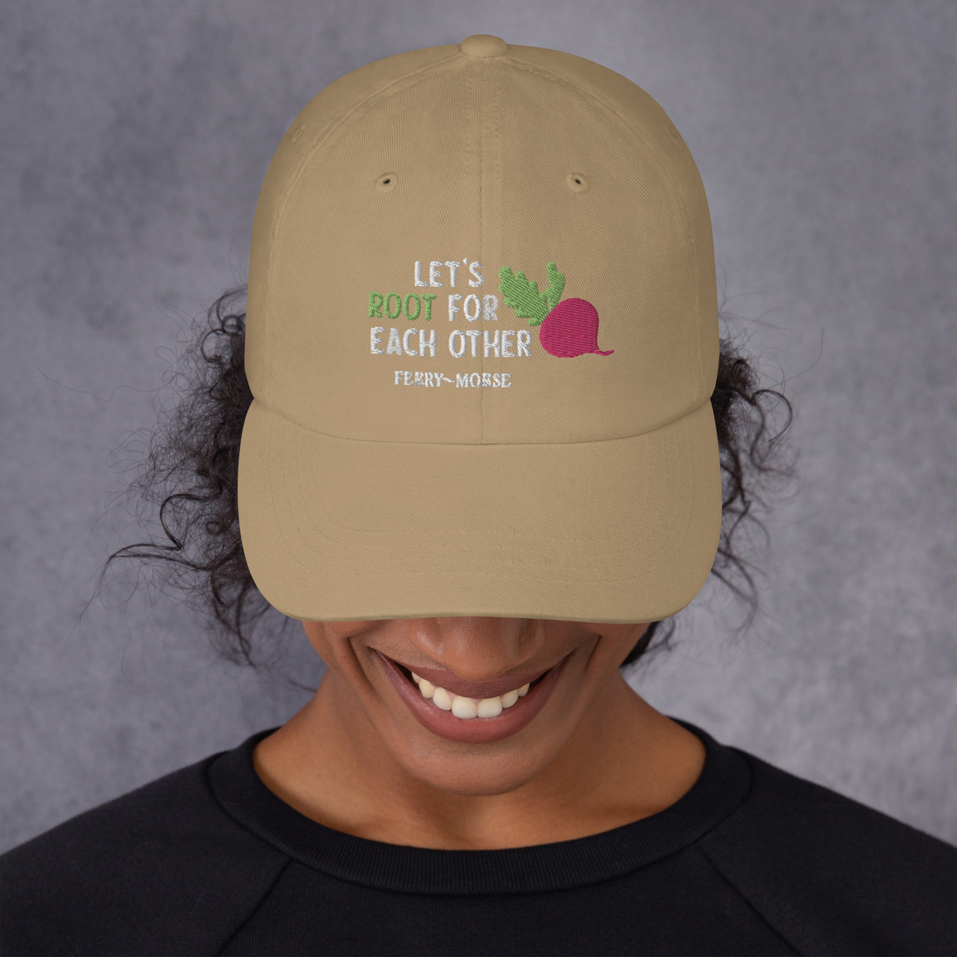 A beige hat with the text 'LET'S ROOT FOR EACH OTHER' and a graphic of a root vegetable on it on female model
