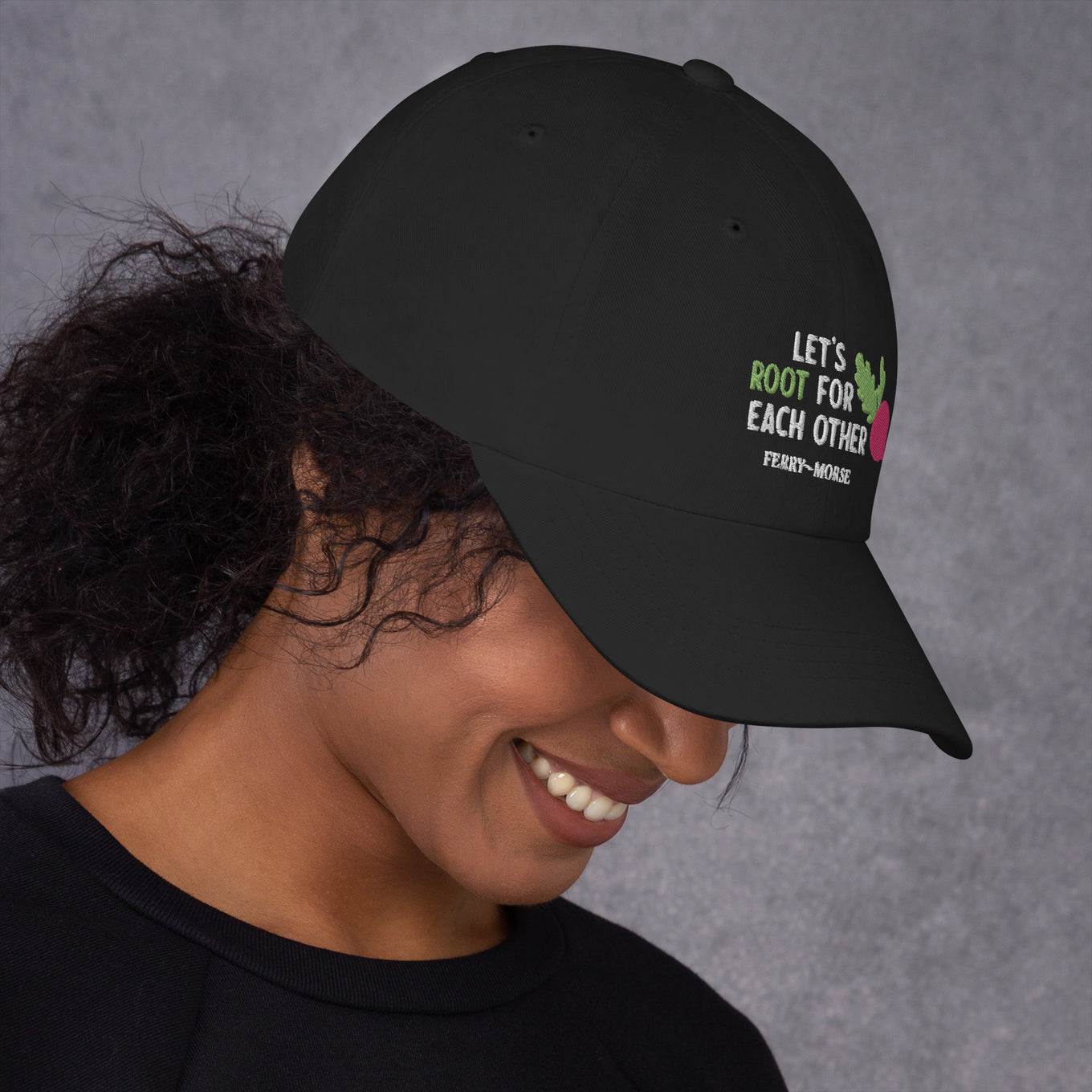A black hat with the text 'LET'S ROOT FOR EACH OTHER' and a graphic of a root vegetable on it on female model