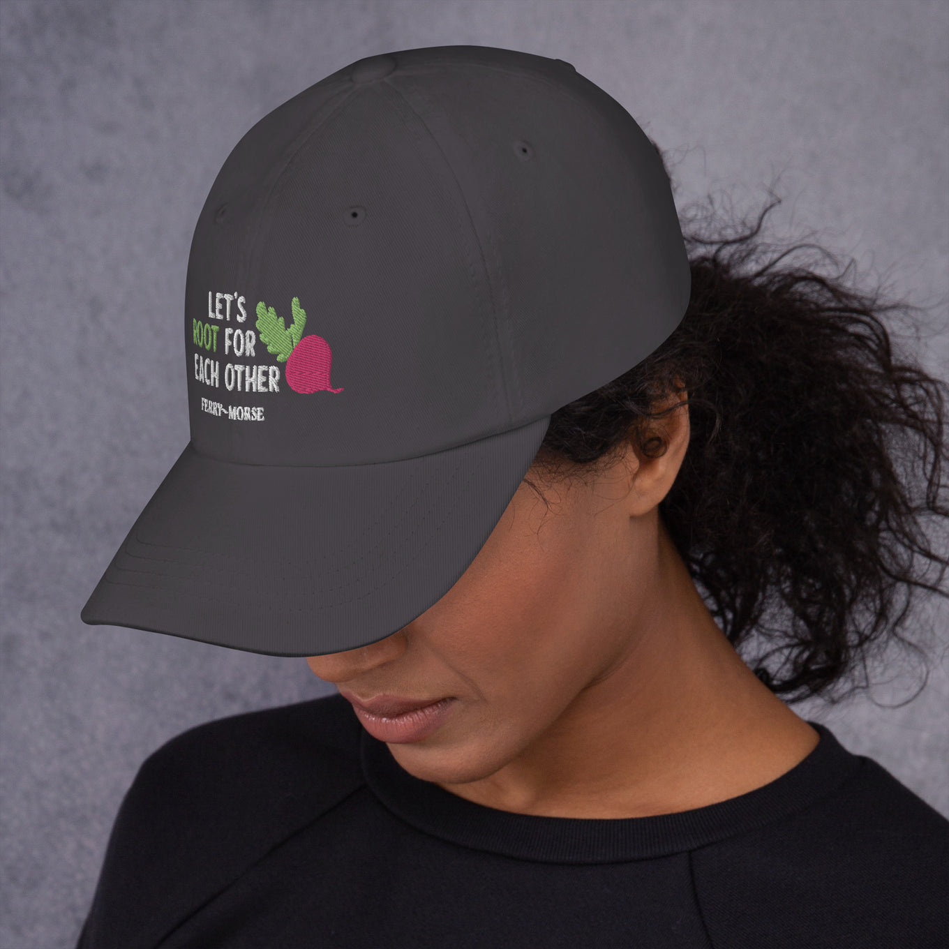 A grey hat with the text 'LET'S ROOT FOR EACH OTHER' and a graphic of a root vegetable on it on female model