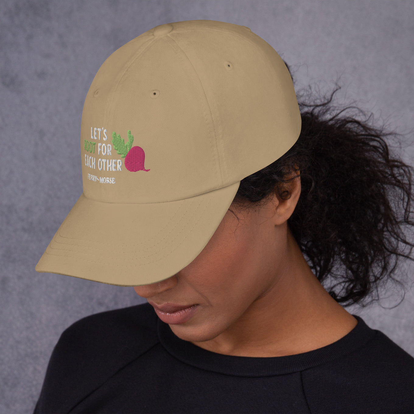 A beige hat with the text 'LET'S ROOT FOR EACH OTHER' and a graphic of a root vegetable on it on female model
