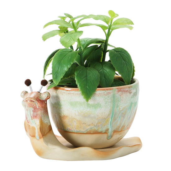 A stoneware planter designed to resemble a snail with a Reactive Glaze finish in beige, brown, and green colors.