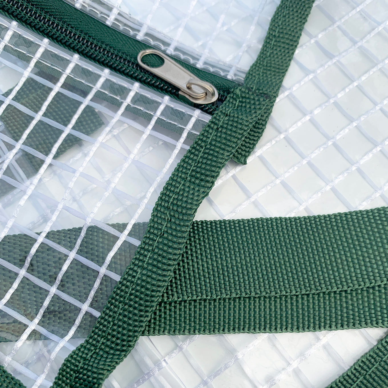 A clear plastic greenhouse cover with dark green edging, designed to fit on an indoor plant stand.
