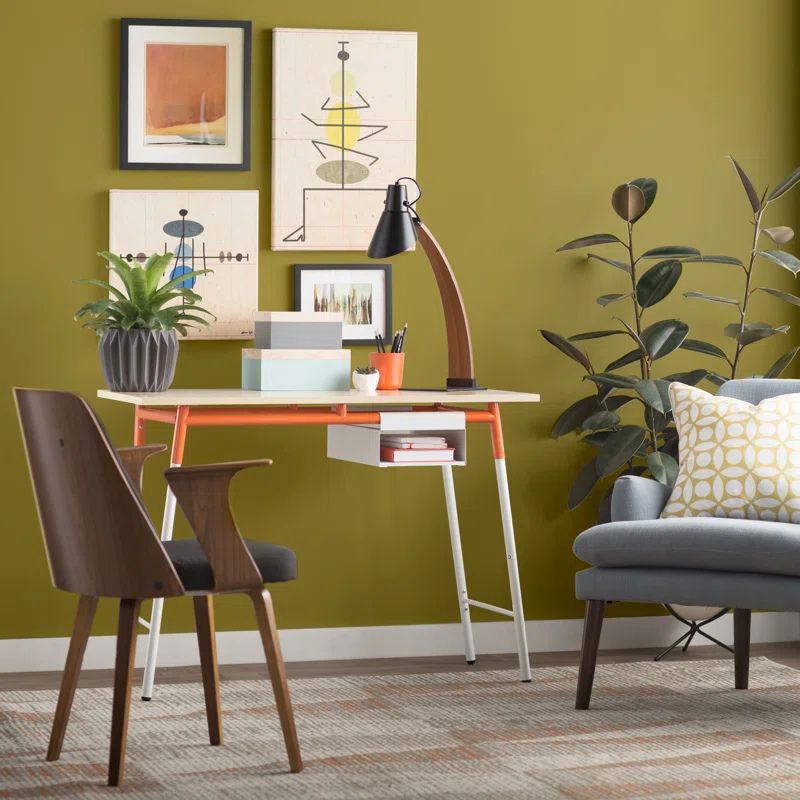 Modern office space with a green wall, desk, chair, and decor.