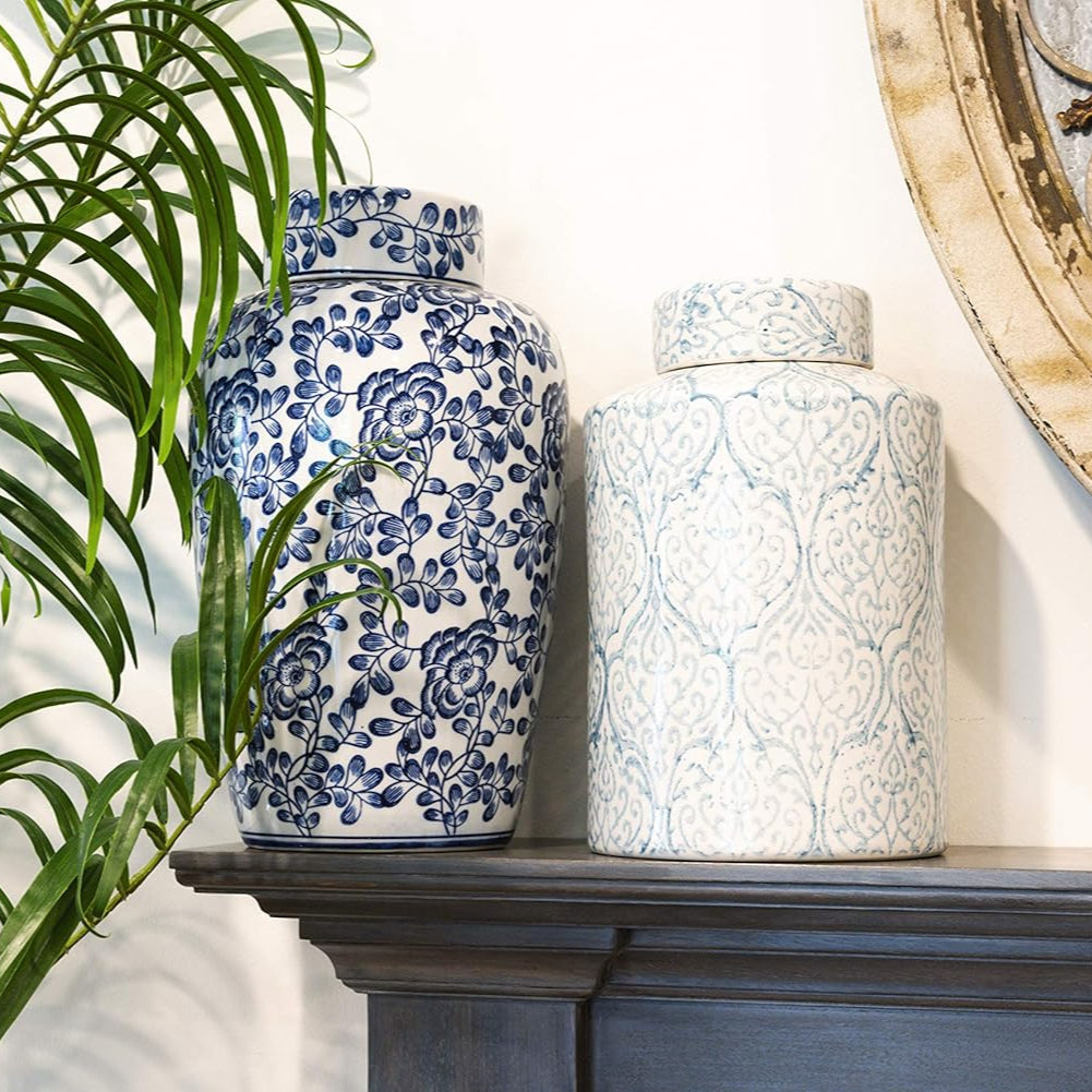 Two decorative vases on a mantelpiece with a plant and wall art in the background.