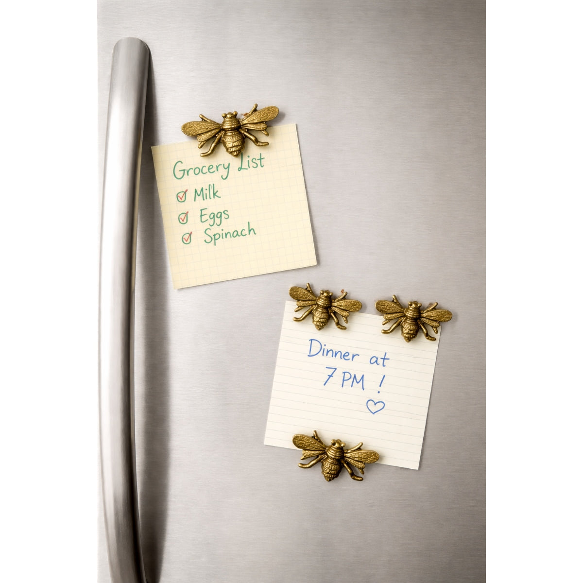 gold bee-shaped magnets holding notes on a refrigerator door.