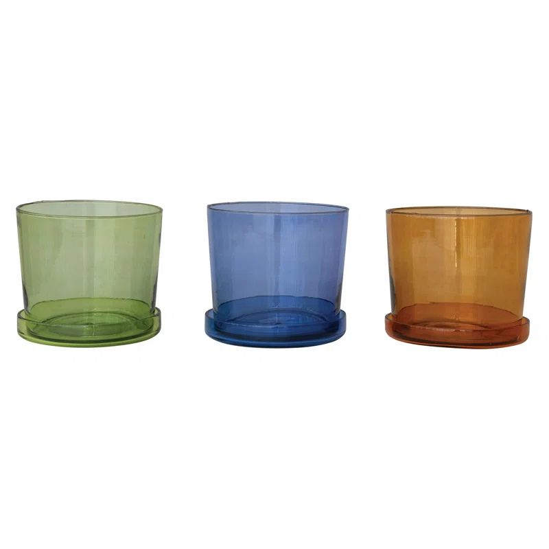Three colorful glass planters in green, blue, and orange on a white background