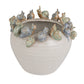 Ceramic planter with snail decorations on a white background