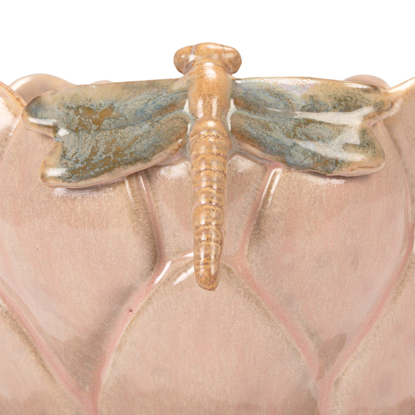 Ceramic dragonfly on a pink ceramic surface
