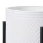 White cylindrical container with black geometric pattern on a white background
