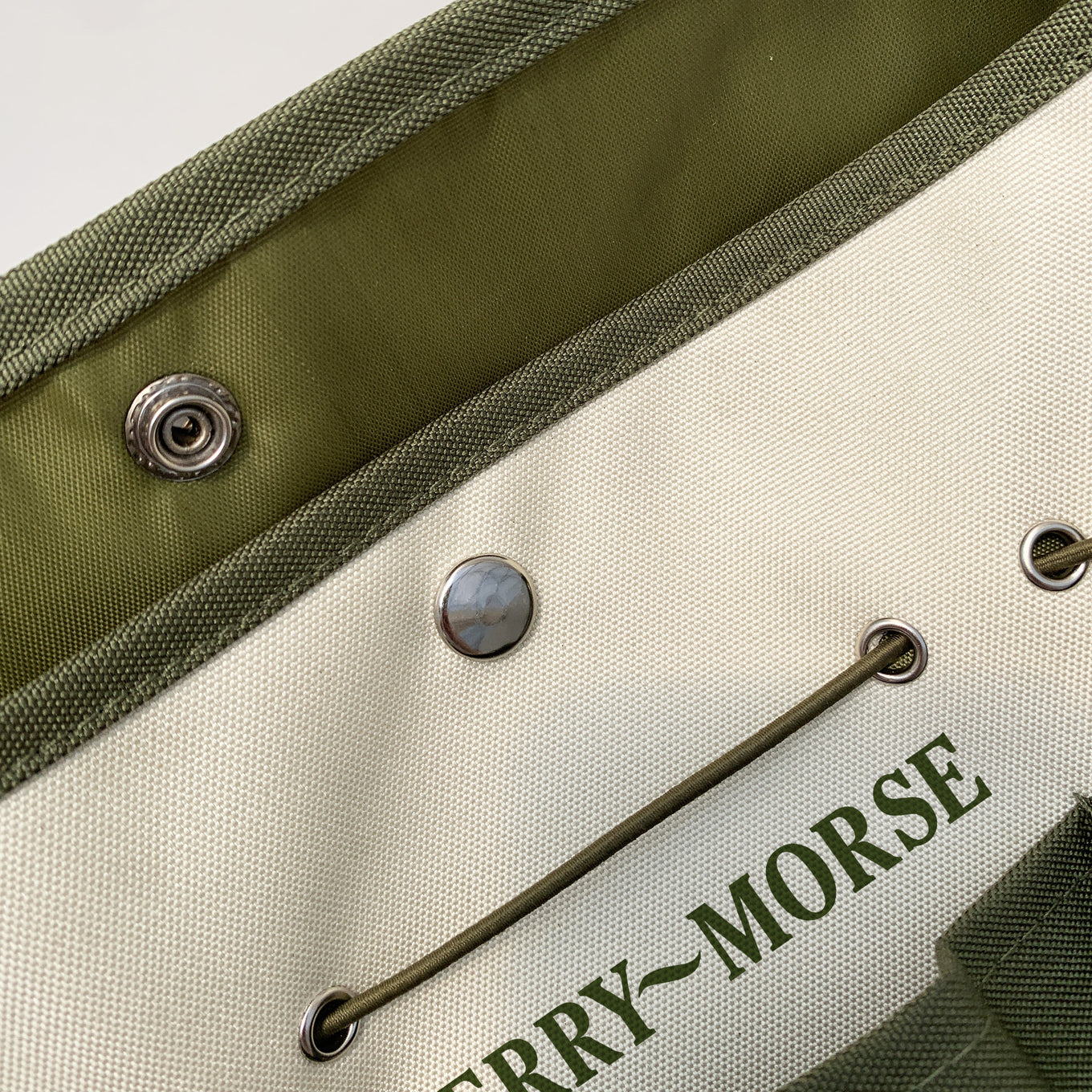 A green and beige Ferry-Morse garden tool bag with multiple pockets and a drawstring closure.