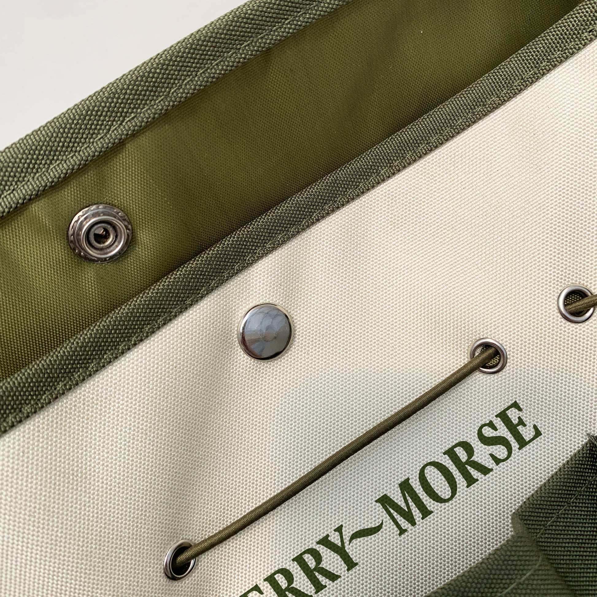 A green and beige Ferry-Morse garden tool bag with multiple pockets and a drawstring closure.