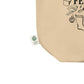 Close-up of a beige canvas tote bag corner with black print and a small white 'certified organic' tag attached near the edge, shown on a white background.