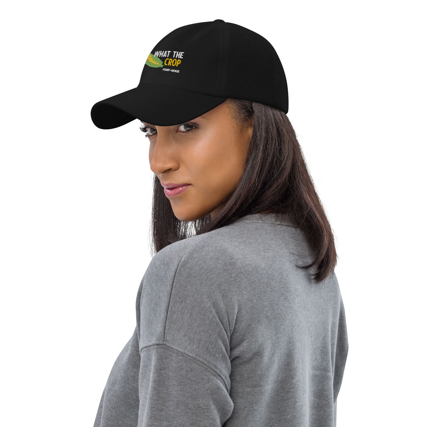 A black 'What The Crop' dad hat with an adjustable strap and curved visor, featuring a graphic of a corn on the front on female model.