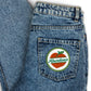 Blue denim jeans with a 'Abundance' patch on the back pocket.