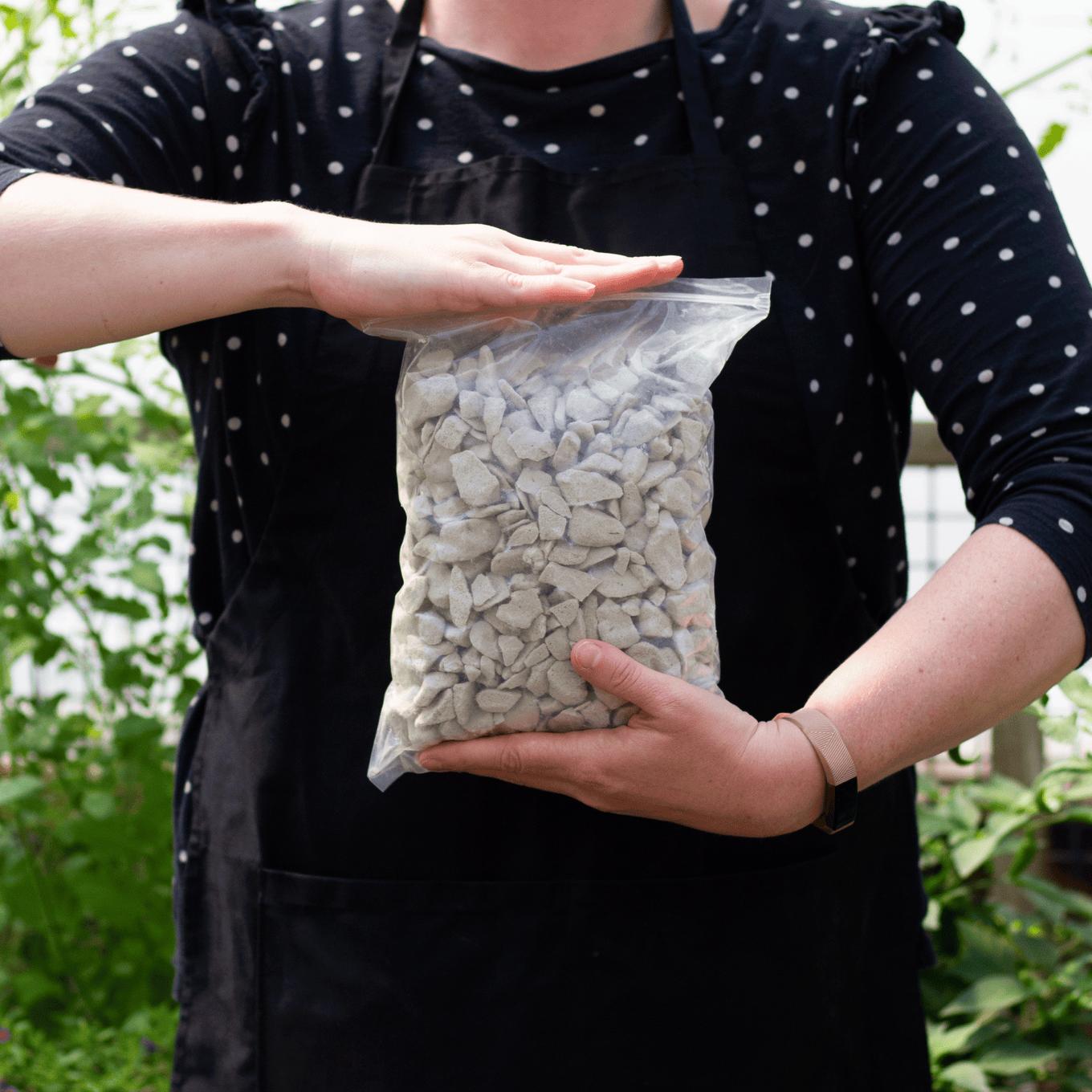 Size reference for soilless growing bag. For reference a gardener is holding the bag in front of their torso. Bag weighs roughly 1lb.